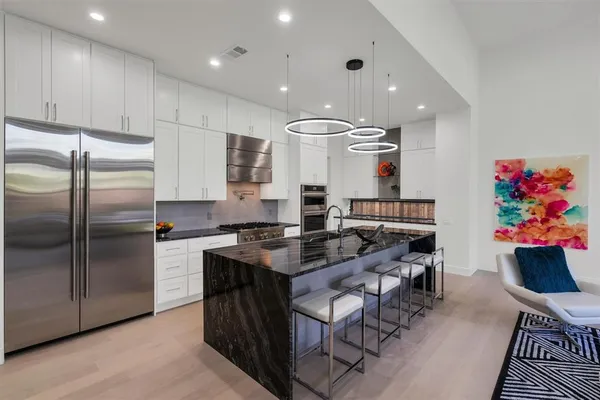 a kitchen with stainless steel appliances granite countertop a sink refrigerator and cabinets