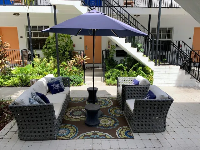 a view of a couches and dinning table with potted plants