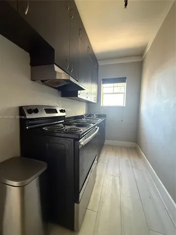 a kitchen with a stove top oven and cabinets