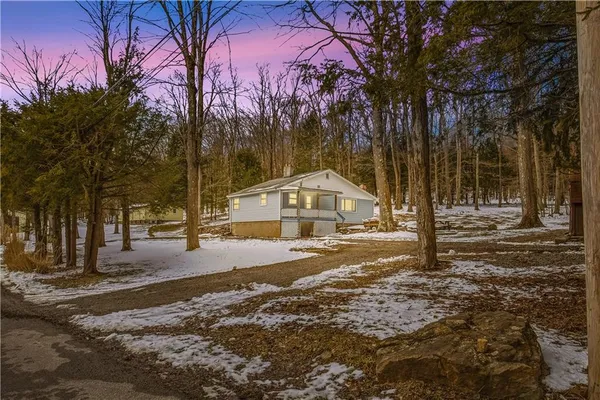 a view of a house with a yard covered in snow