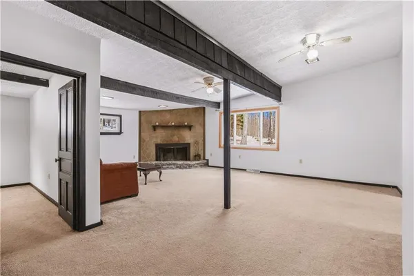 a view of an empty room with chandelier fan and windows