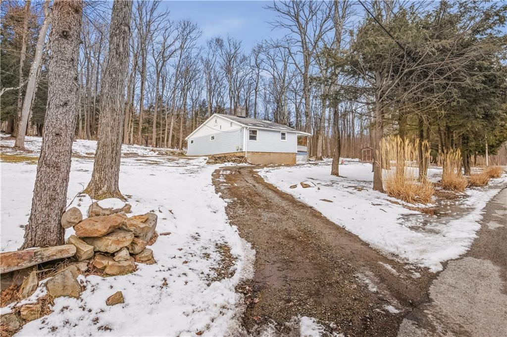 255 Evergreen Lane Acme, PA 15610 - Photo 22 of 27 a view of a yard with snow on the road