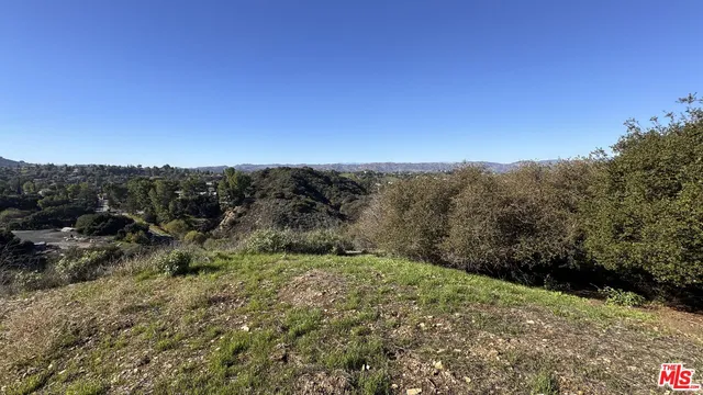a view of a dry yard with mountains in the background