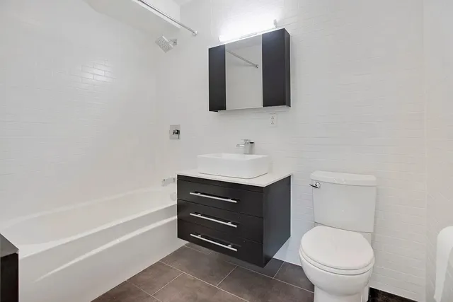 a spacious bedroom with a bed and a flat screen tv