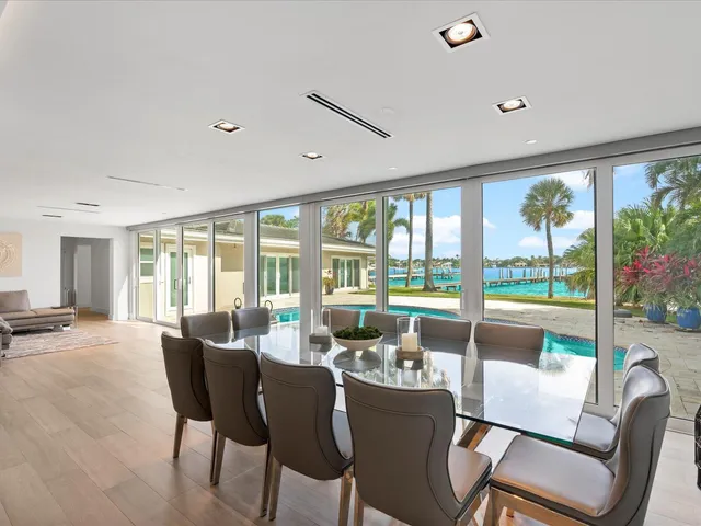 a view of a dining room with furniture large windows and wooden floor