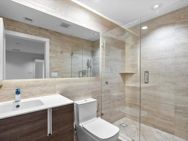 a bathroom with a sink toilet a mirror and shower