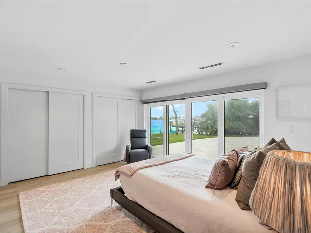 a bedroom with a bed and large windows