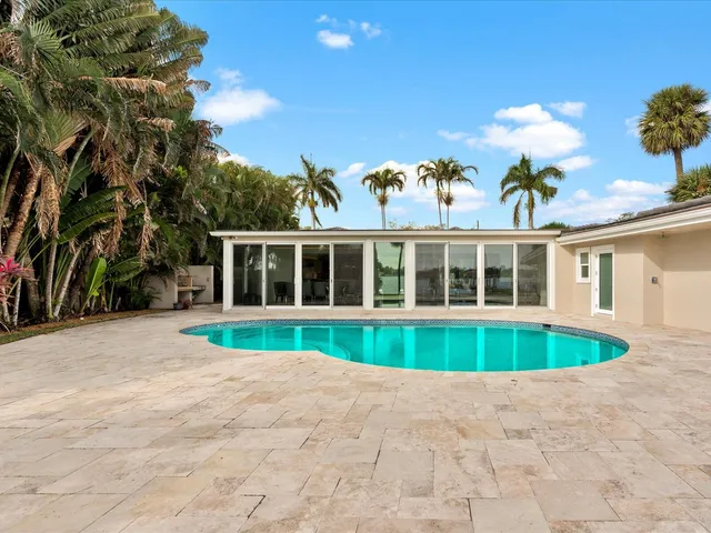 a front view of a house with a yard and potted plants