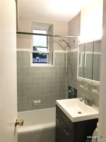 a bathroom with a sink mirror and a bathtub