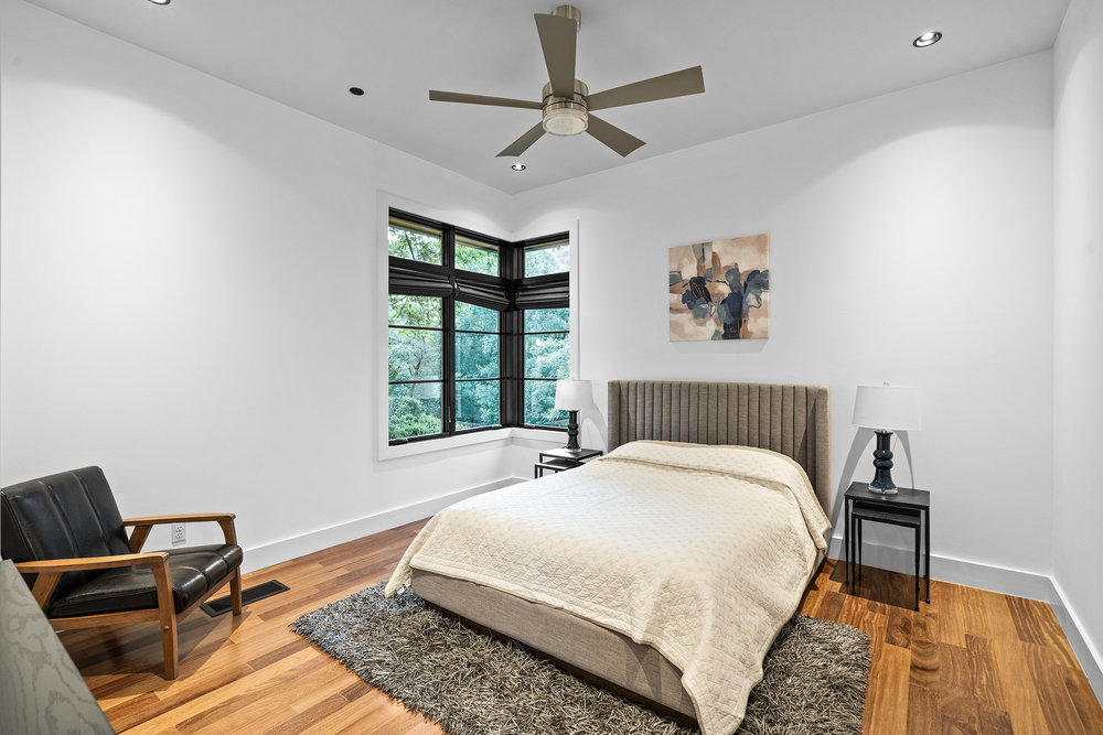 1905 Paisano Road Austin, TX 78746 - Photo 19 of 40 Hardwood floors and a large corner window illuminate this quiet, private sleeping space.