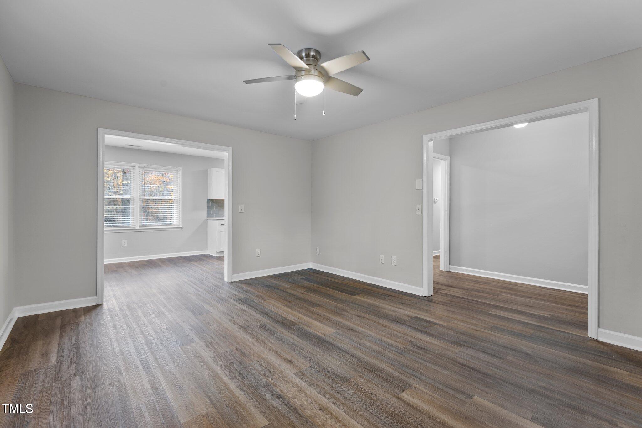 6415 Whitt Road Durham, NC 27712 - Photo 16 of 37 an empty room with wooden floor ceiling fan and windows