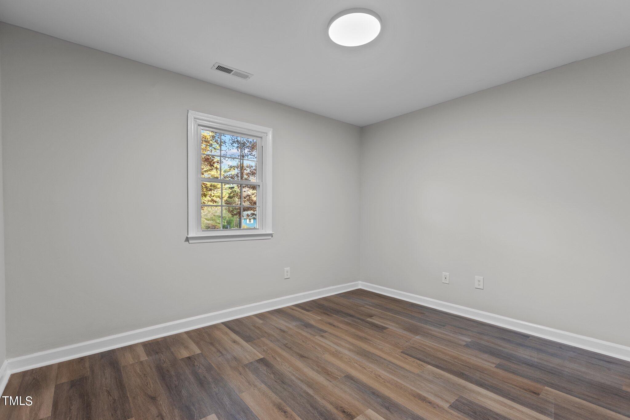 6415 Whitt Road Durham, NC 27712 - Photo 19 of 37 an empty room with wooden floor and windows