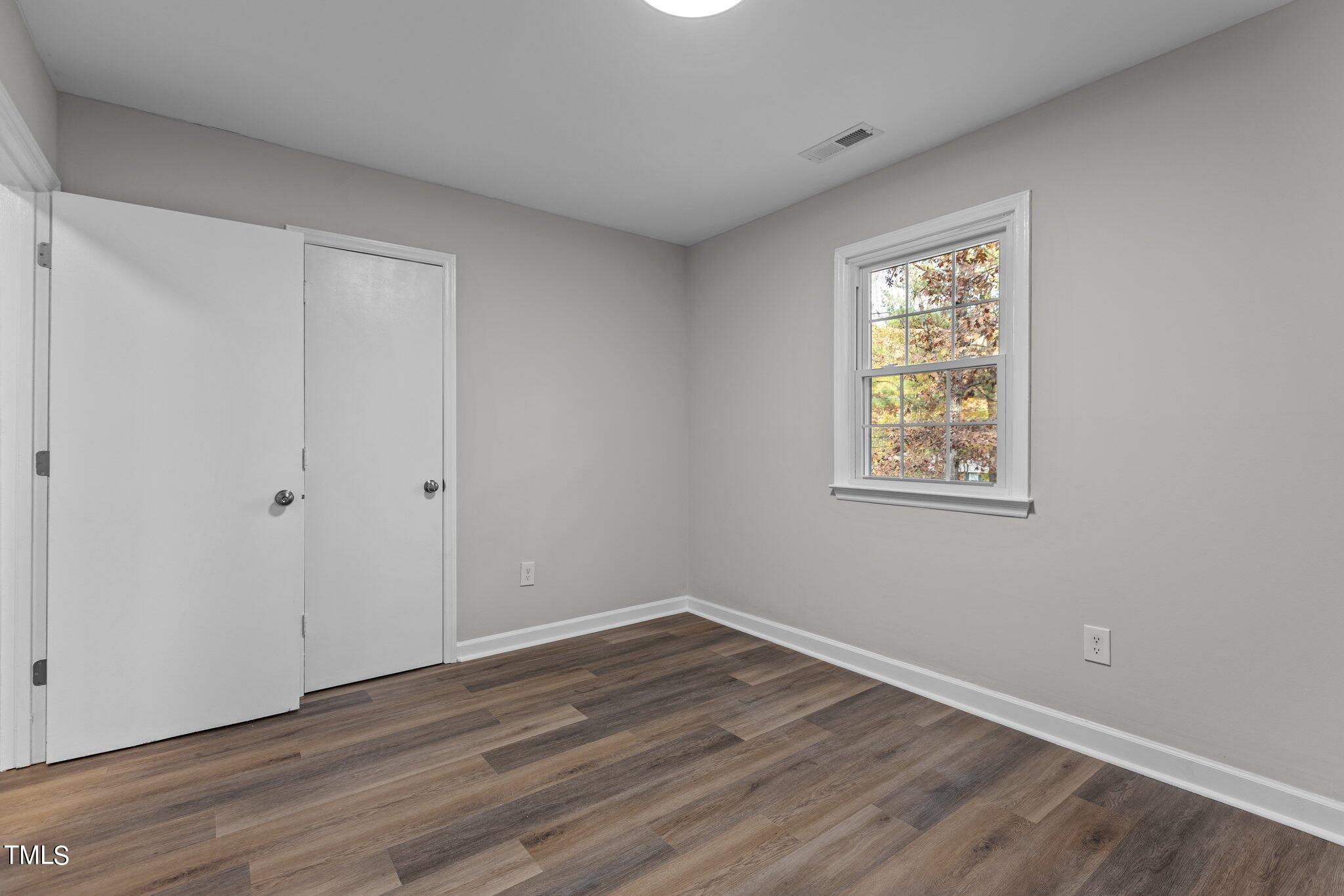 6415 Whitt Road Durham, NC 27712 - Photo 20 of 37 a view of an empty room with wooden floor and a window
