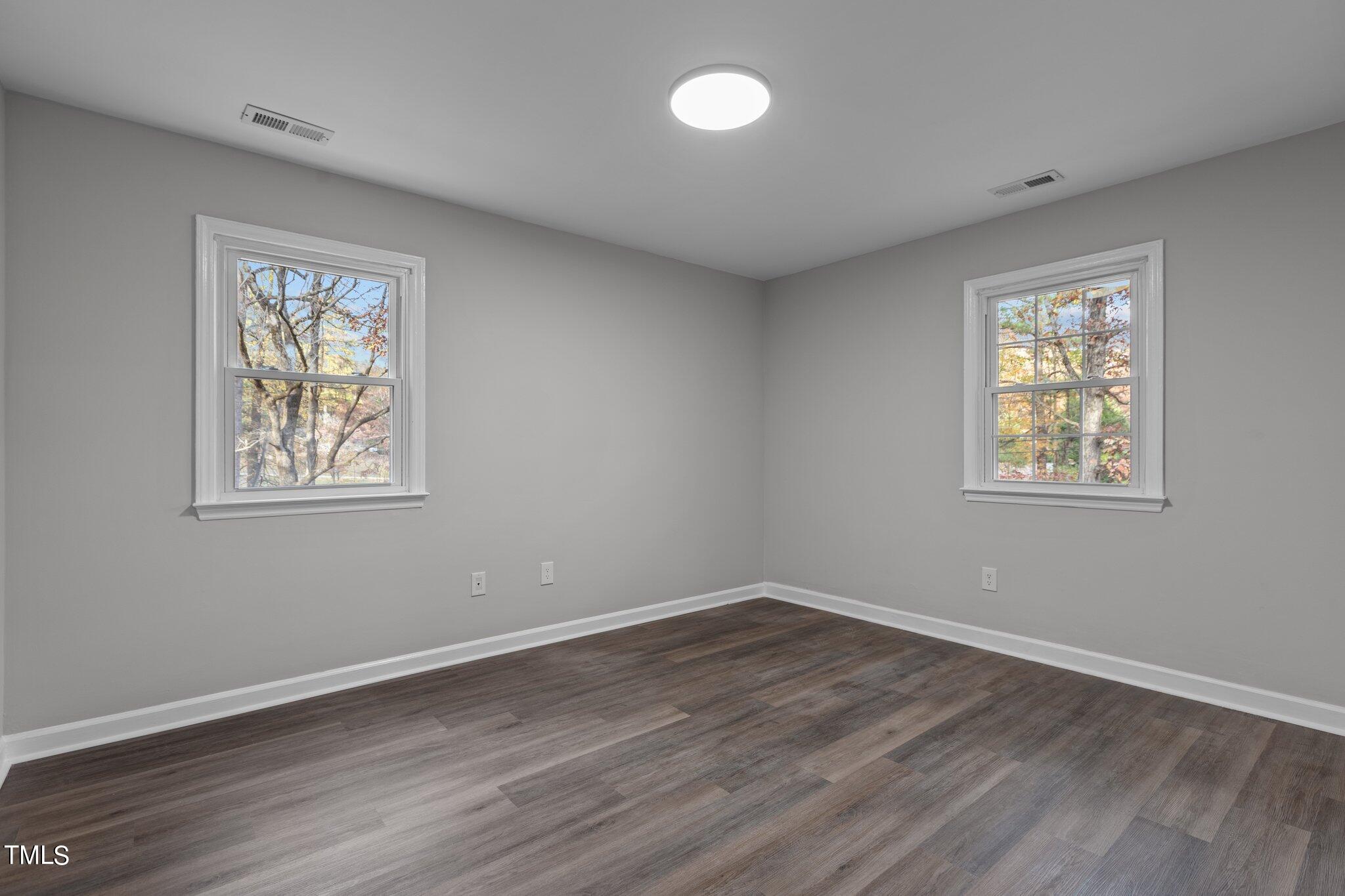 6415 Whitt Road Durham, NC 27712 - Photo 21 of 37 a view of an empty room with wooden floor and a window