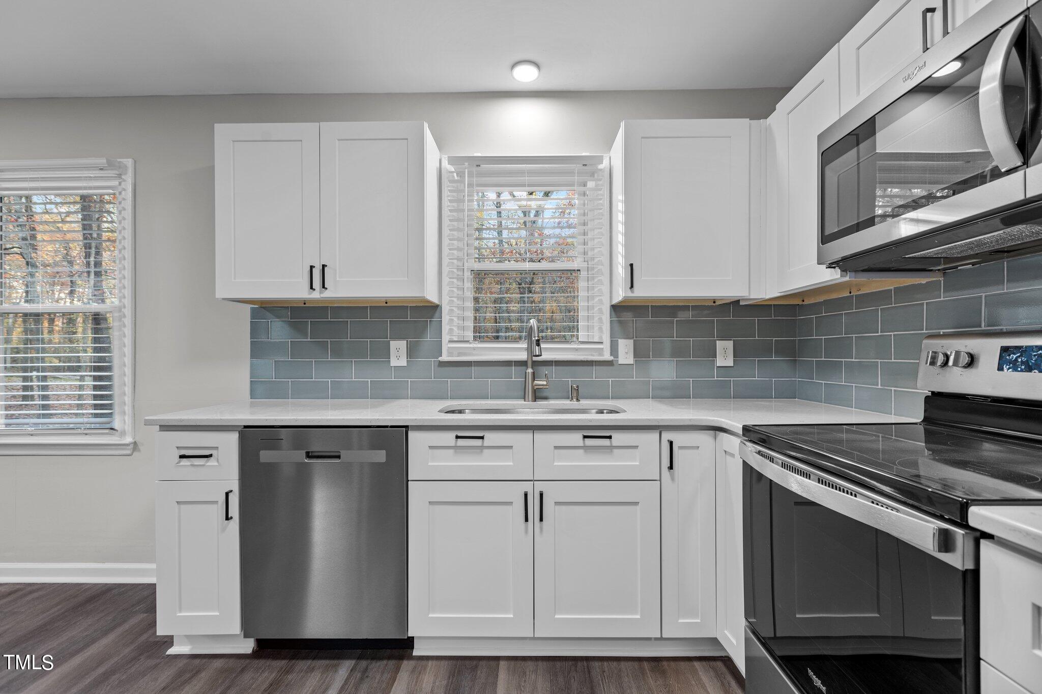 6415 Whitt Road Durham, NC 27712 - Photo 9 of 37 a kitchen with cabinets appliances a sink and a window