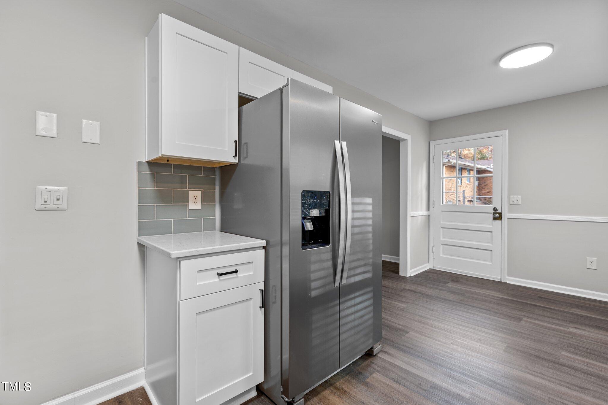 6415 Whitt Road Durham, NC 27712 - Photo 10 of 37 a kitchen with white cabinets and wooden floor