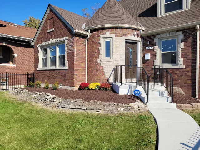 a view of a house with backyard and sitting area