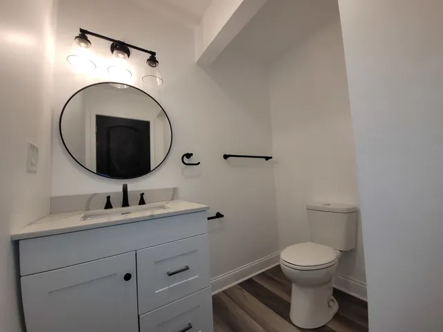 a bathroom with a toilet sink and mirror
