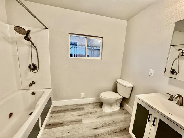a bathroom with a tub shower and vanity