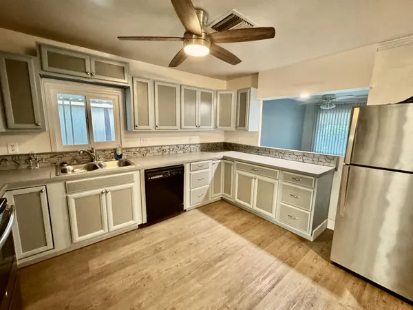 a kitchen with stainless steel appliances granite countertop a stove a sink and a refrigerator