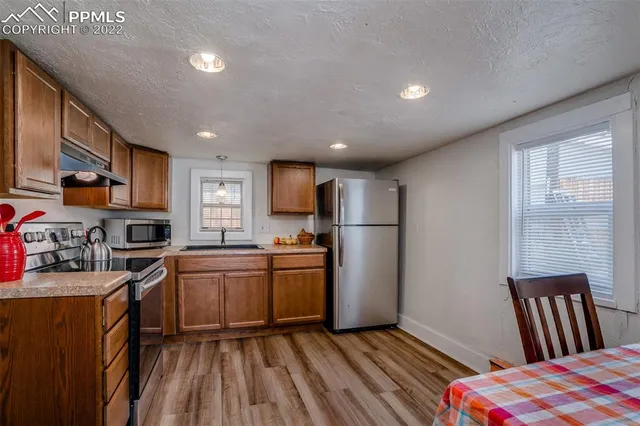 a kitchen with granite countertop a sink cabinets and stainless steel appliances