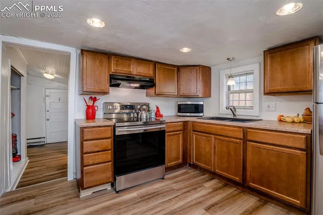 a kitchen with stainless steel appliances granite countertop wooden cabinets sink and stove top oven