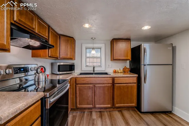 a kitchen with stainless steel appliances granite countertop a sink stove and refrigerator