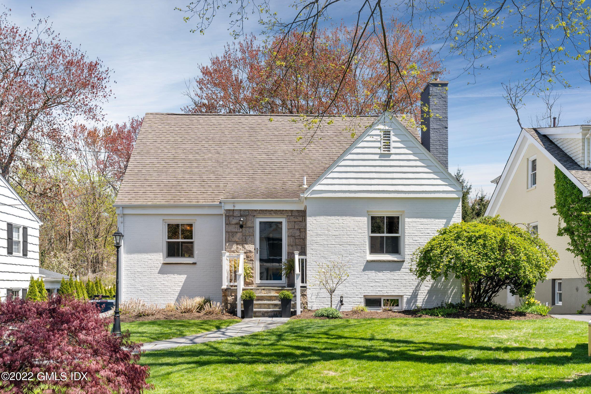 a front view of a house with a yard and trees