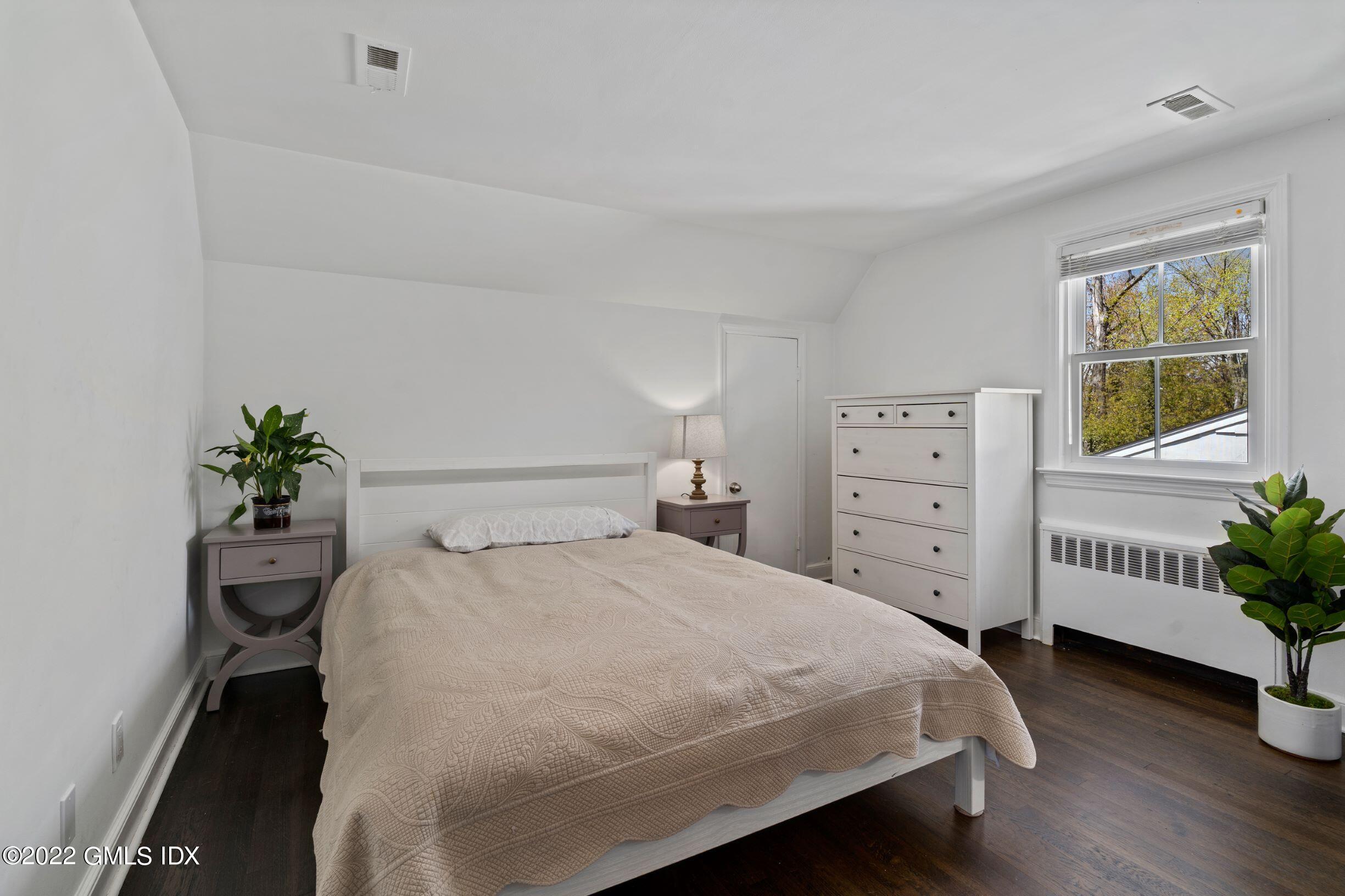 23 Manor Road Old Greenwich, CT 06870 - Photo 14 of 25 a bedroom with a bed and a potted plant