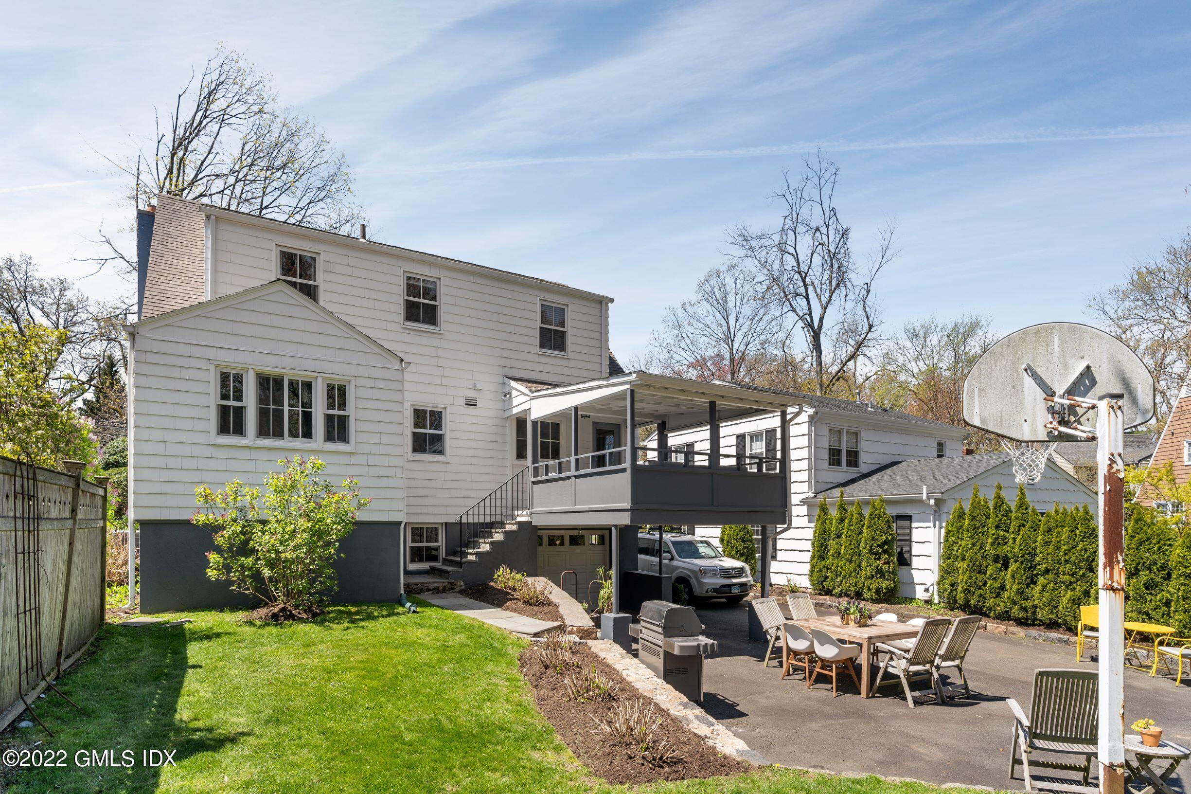 23 Manor Road Old Greenwich, CT 06870 - Photo 25 of 25 a front view of a house with a yard table and chairs