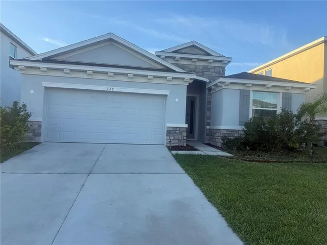 a front view of a house with a garden and yard