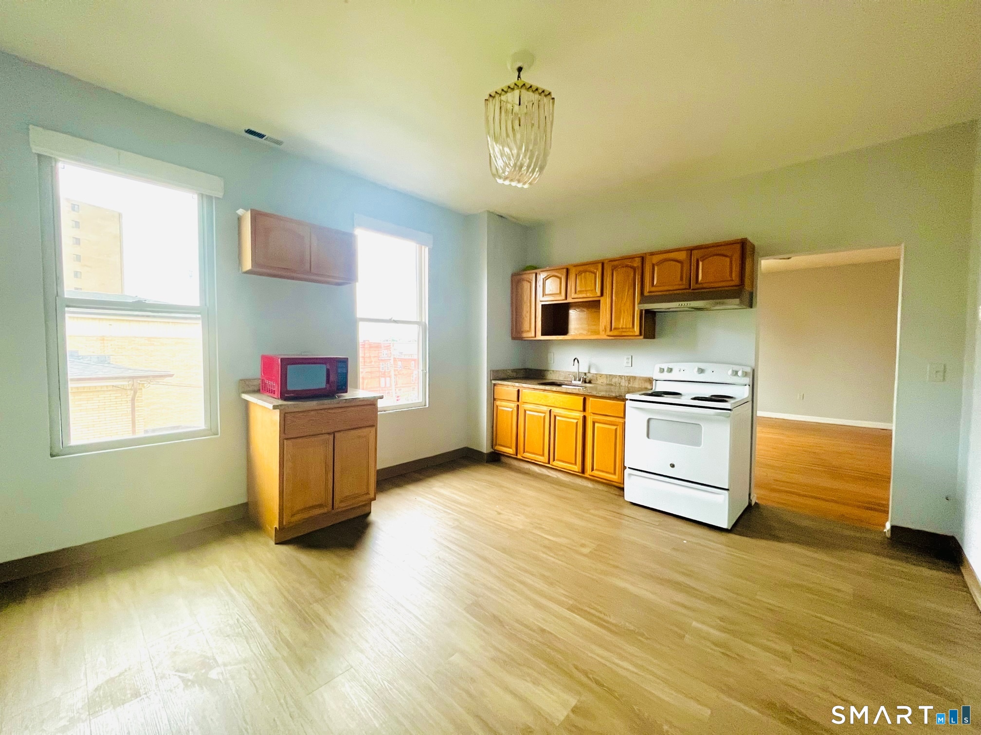 162 William Street, Unit 3R Bridgeport, CT 06608 - Photo 4 of 7 a kitchen with stainless steel appliances a kitchen island wooden floors and a sink