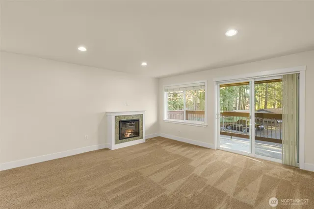 a view of an empty room with a fireplace and a window