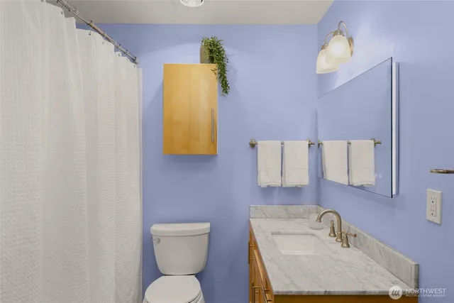 a bathroom with a sink toilet and mirror