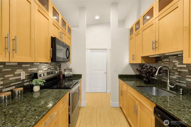 a kitchen with sink a microwave and cabinets
