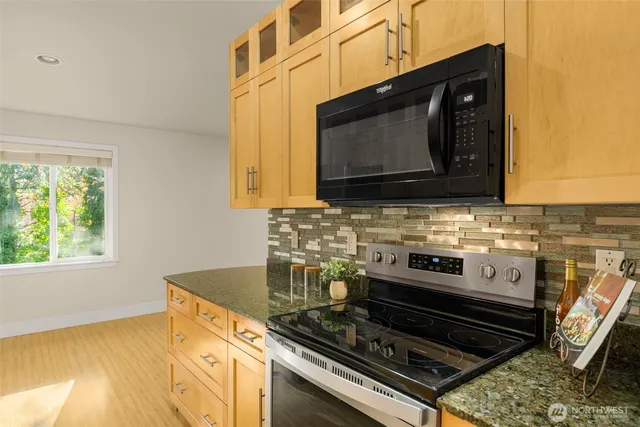 a kitchen with a stove a microwave and sink