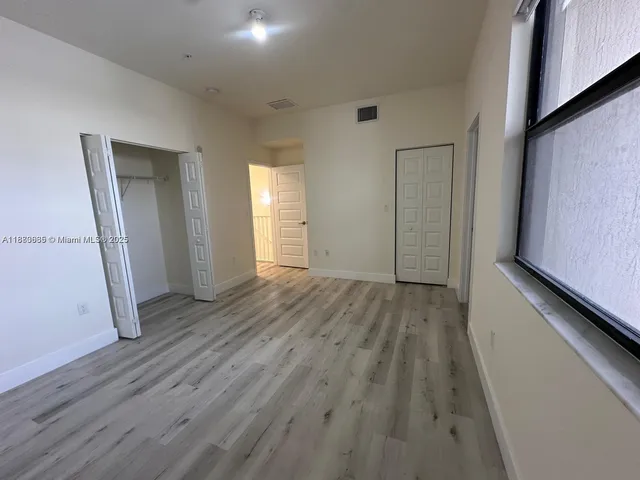 a view of empty room with wooden floor