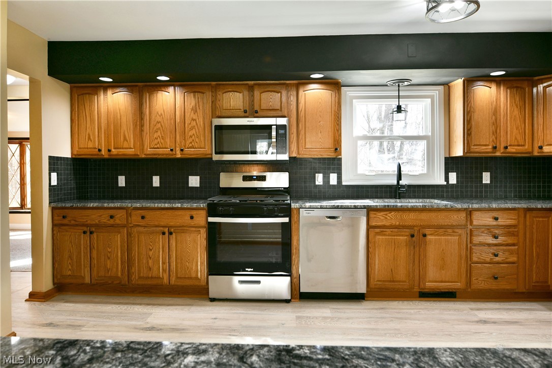 105 Fairview Avenue Cortland, OH 44410 - Photo 15 of 47 Kitchen with stainless steel appliances, wood finish cabinetry, light wood-style flooring, dark stone counters, and recessed lighting