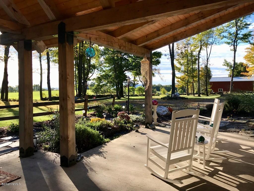 49 Forget Road Hawley, MA 01339 - Photo 29 of 30 a view of a patio with table and chairs potted plants and floor to ceiling window with wooden fence