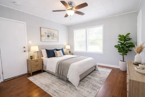 a bedroom with a large bed and a potted plant