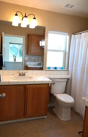 a bathroom with a sink a toilet and mirror