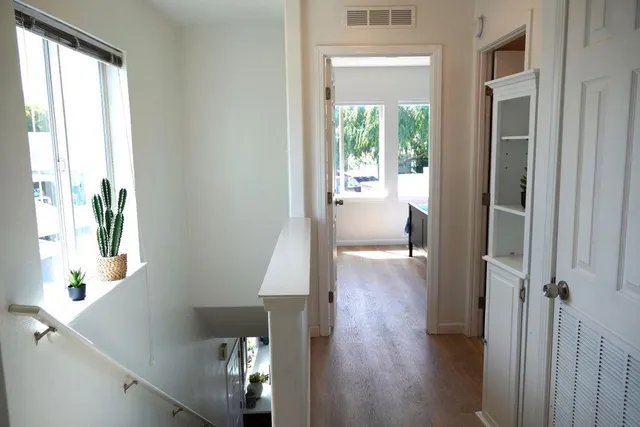 a view of a hallway with wooden floor and stairs