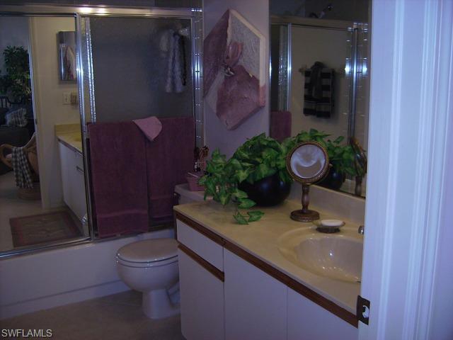 265 Deerwood Circle, Unit 3 Naples, FL 34113 - Photo 7 of 14 a bathroom with a granite countertop sink a toilet and shower