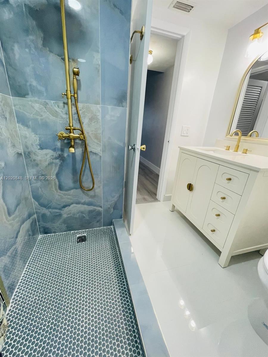 9175 Southwest 77th Avenue, Unit 306 Miami, FL 33156 - Photo 11 of 16 a bathroom with a sink a mirror and shower