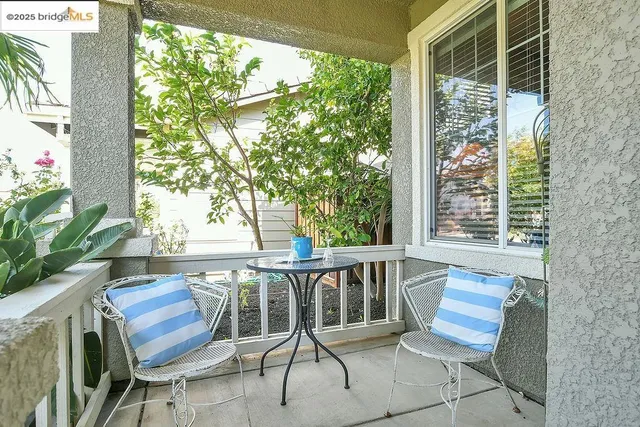 a balcony with wooden floor and outdoor seating