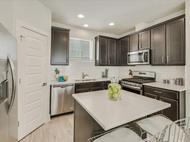 a kitchen with stainless steel appliances a stove sink and microwave