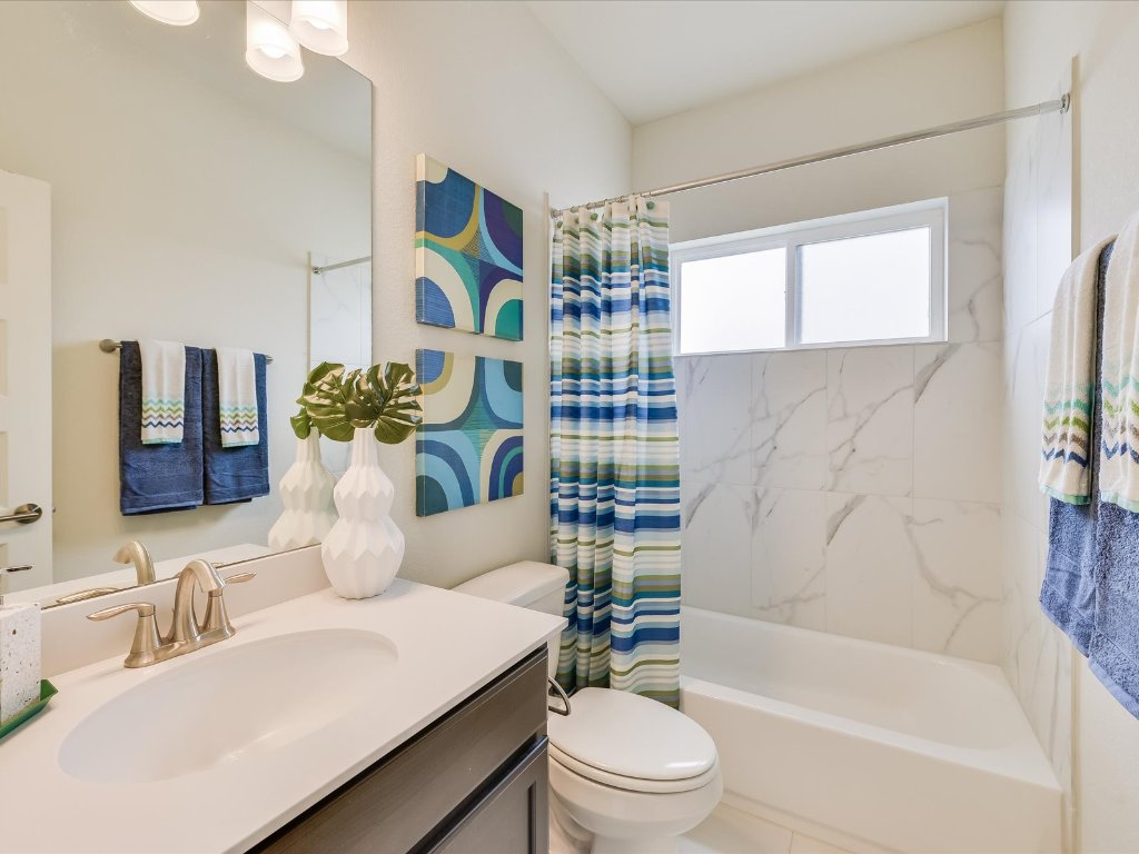 1916 Warely Lane Austin, TX 78741 - Photo 10 of 15 a bathroom with a bathtub sink vanity mirror and toilet
