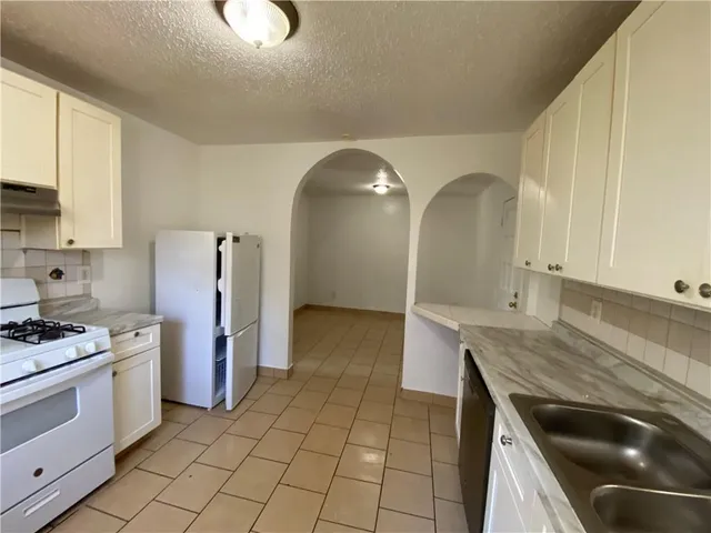 a kitchen with a sink a stove and refrigerator