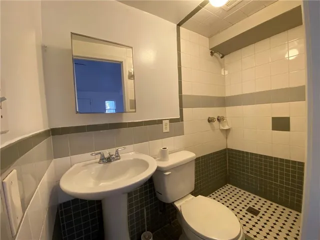 a bathroom with a sink toilet a mirror and shower