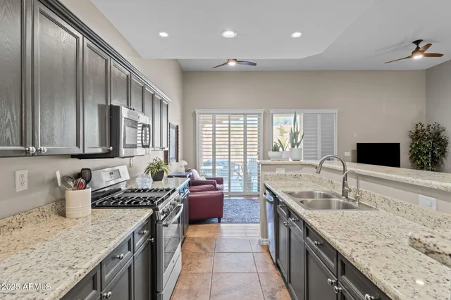 a kitchen with stainless steel appliances granite countertop a sink stove and cabinets